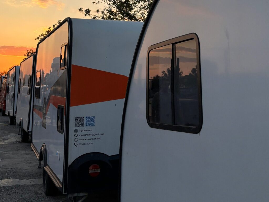 Service-3-min A scenic view of caravans lined up under a vibrant sunset sky in İzmir, Türkiye.